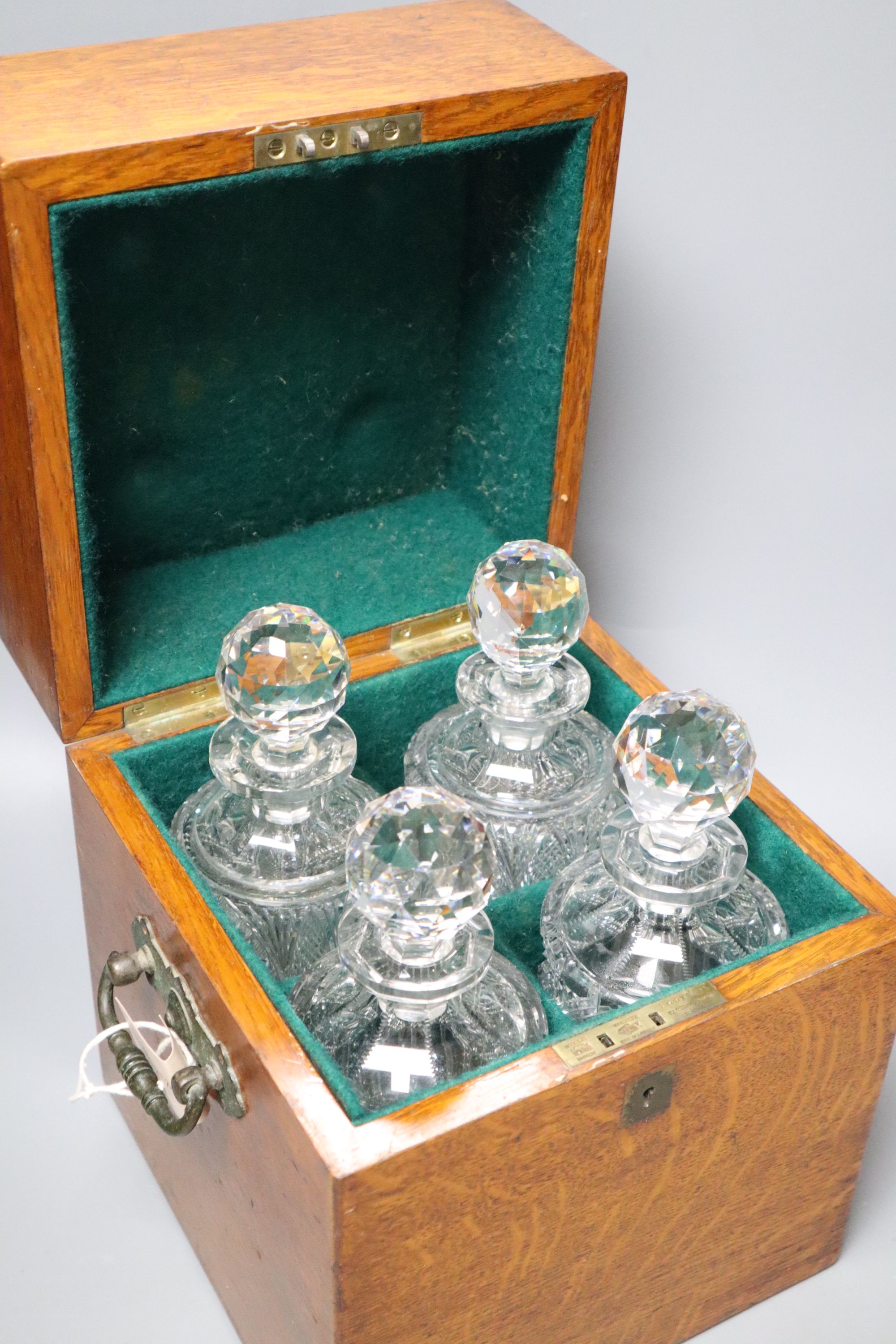 A Victorian oak four decanter box containing two pairs of cut glass decanters, overall height 30cm